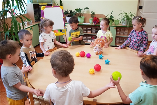 Девочки и мальчики играют с мячиками.