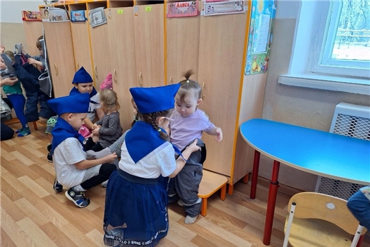 Тимуровская команда помогает малышам одеваться на прогулку.